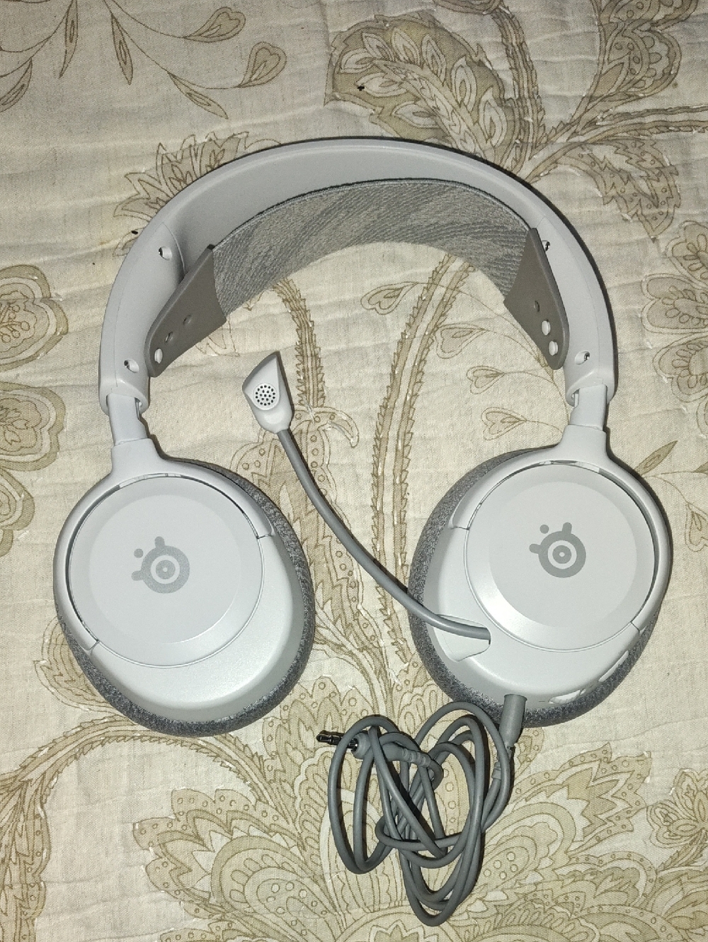 white SteelSeries Arctis Nova 1P wired gaming headphones. [1]